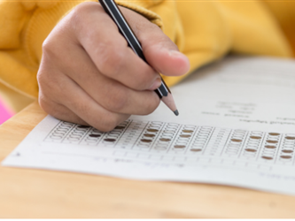 A person is writing on a piece of paper with a pencil