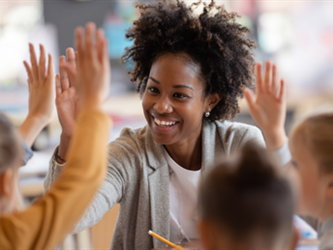 student raising their hands in the classroom